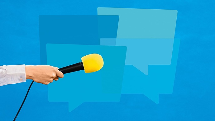 Eine Hand, die ein Mikrofon mit einem gelben Schaumstoffüberzug hält, wird von links vor überlappenden blauen Sprechblasensymbolen auf blauem Hintergrund ausgestreckt.