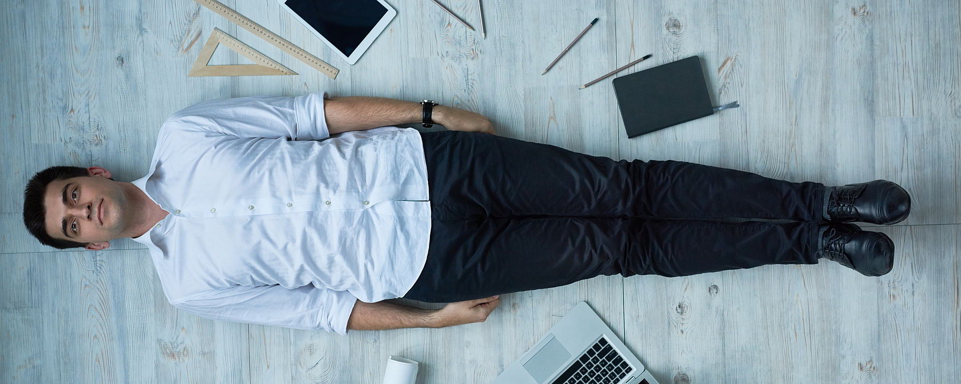 Mann liegt auf Schreibtisch