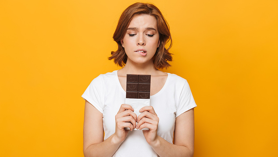 Frau mit einer Tafel Schokolade in der Hand